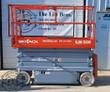 Orange SkyJack SJIII 3226 scissor lift, side view with the platform lowered, gray scissor stack and steel base