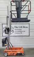 JLG 12SP raised with a worker in the platform, aluminum mast partly extended above the orange base