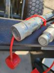 Hydraulic quick-connect couplers with red dust caps mounted on the log grapple crossbar