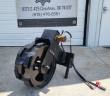Trench compaction wheel on its park stand, welded cleats, hydraulic motor and red-capped hose couplers