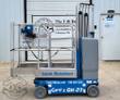 Genie GR-20 Runabout vertical mast lift in blue, guardrailed platform, hand controller on a coiled cord, mast lowered