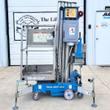 Genie AWP-25S push-around lift: blue base with outriggers, aluminum mast and platform with control panel