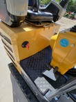 MX12RX mini excavator operator floor: rubber mat and travel pedal, red rotary shutoff switch, seat above the tank