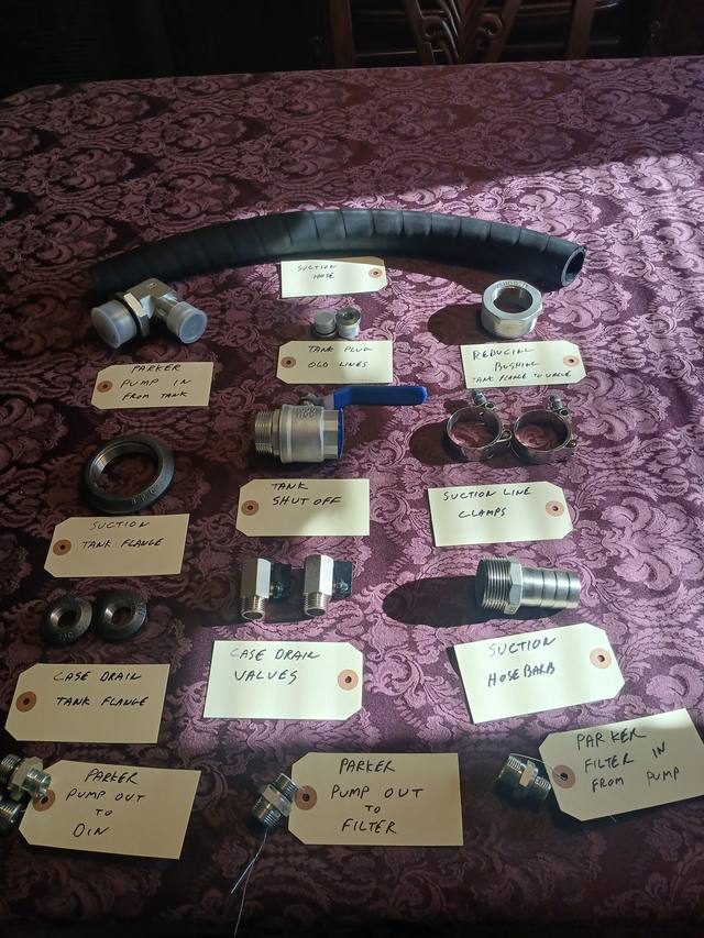 Parker pump install kit laid out and tagged: suction hose, hose barb, clamps, tank flanges, shut-off, drain valves, fittings