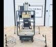 JLG push-around manlift: steel platform with guardrails, control panel on the mast and four leveling outriggers