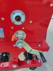 No till seed drill drive hub and orange seed-rate adjustment knob with release lever on the red frame