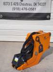 Orange Wolverine hydraulic clamp with cylinder, coiled hoses, jaw teeth and excavator mounting pins