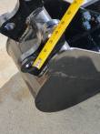 Tape measure along the trenching bucket's pin ears and boss, curved black side plate below
