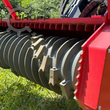 Replaceable cutting teeth on the drum with red hydraulic motor housing visible.