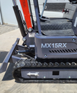 MX15RX body decal on the gray housing, with backfill blade, hydraulic cylinder and rubber track