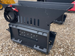 WIG asphalt block crusher: gray steel hopper with slotted vents, quick-attach mount and coiled hydraulic hoses