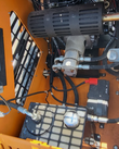 QB-480 mini skid steer engine bay: gas engine muffler, hydraulic gear pump, battery and hydraulic tank