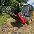 Red disc mulcher tilted up on a JCB skid steer, cutting disc and bolt-on teeth packed with cut vegetation