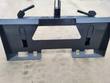 Rear of the Wolverine hitch adapter: skid steer quick-attach plate with mounting slots and lock lever handles