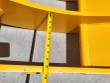 Tape measure spanning the gap between the yellow rake's curved frame bars, reading about 10 inches