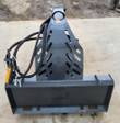 Rotating grapple's universal skid steer quick-attach plate, Wolverine-decal boom arm and hydraulic hose routing