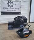 Rotating grapple attachment, full view: curved boom arm, hydraulic rotator and open toothed jaws with orange pads