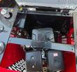 Open engine compartment of a mini excavator showing the gasoline engine, fuel tank and hydraulic fittings