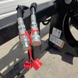 Two hydraulic quick-connect couplers with red dust caps, mounted to the auger's frame