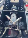 Hydraulic drive motor with hoses and relief block mounted above the brush cutter gearbox, inside the housing