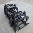 Black dual-clamp root grapple, twin hydraulic cylinders and serrated tines, clamps raised