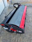 76-inch smooth-drum vibratory roller, end plate with bolted red hub, red scraper blade and hydraulic hoses coiled on top