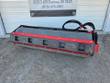 Raytree 76-inch vibratory roller, front view, smooth steel drum behind a red bolt-on scraper blade, hydraulic hoses on top