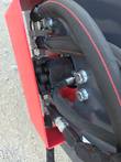 Hydraulic drive motor mounted to the vibratory roller's red end frame, hoses attached