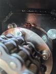 Soil conditioner drive sprocket and chain, mounting bolts with red torque paint marks
