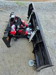 6-way dozer blade angled, red hydraulic angle cylinders, trip springs and adjustable skid shoes behind the moldboard