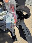 Grader blade remote control panel, wrapped in plastic, labeled left/right/blade buttons