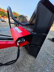 Hydraulic motor and gearbox mounted on the cutting head's red angled bracket