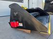 Raytree power rake bucket, rear three-quarter view showing the manufacturer ID plate on the sidewall