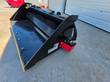 Raytree power rake bucket, drive-end view with red hydraulic motor housing, hoses, and yellow cutting edge