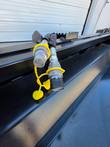 Power rake bucket's hydraulic quick-connect couplers with yellow dust caps, mounted at the hitch