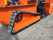 Rubber track and drive sprocket on the orange tracked mower body, flail head housing at right