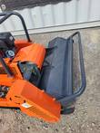 Flail head housing with mesh guard bar and bearing mount on the front of the orange tracked mower