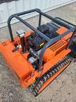 Top view of the tracked mower's gas engine, fuel tank, grey roll cage and rear crank jack stand