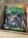 Green remote control mower wrapped in plastic inside a wooden shipping crate, seen from above, RATO engine and actuators