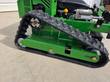 Left rubber track and drive sprocket of a green tracked mower, with linear actuator and engine above