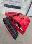 Red tracked remote control mower from a rear three-quarter angle, vented hood, LED lights and wide rubber tracks