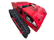 Red tracked remote control mower, front three-quarter view: vented steel hood, two front lights, rubber tracks