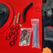 Included accessories: wrenches, bent fill hose, spare seals and tool bags laid on the red sprayer tank