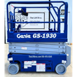 Blue Genie GS-1930 scissor lift, side profile, platform lowered on the scissor stack, guardrails up, solid tires