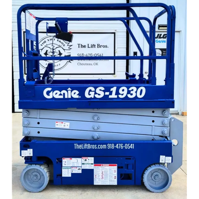 Blue Genie GS-1930 scissor lift, side profile, platform lowered on the scissor stack, guardrails up, solid tires
