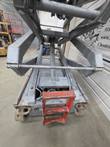 Skyjack SJIII 4632 with platform raised, gray scissor arms and chassis viewed from the ladder end