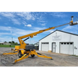 Yellow Haulotte 3632T towable boom lift on its trailer chassis, boom extended and platform raised on four outriggers