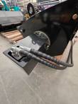 Hydraulic hoses in black spiral wrap running to the drive motor mount on a mixing bucket side plate