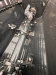 Bolted center shaft with mixing paddles and flange along the floor of a black concrete mixing bucket