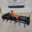 Wolverine 3-point box blade with six ripper shanks lowered, orange hitch tower and black frame